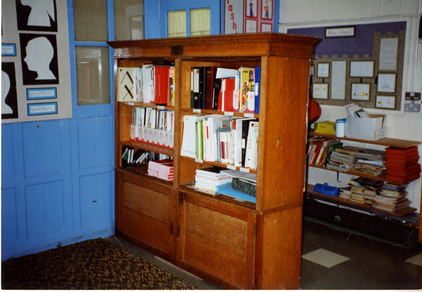 Photograph of a bookcase in Llangwm School with a set of files on it